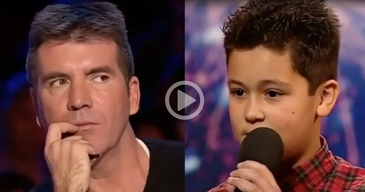 A young boy sings into a microphone while a man in a suit listens intently.