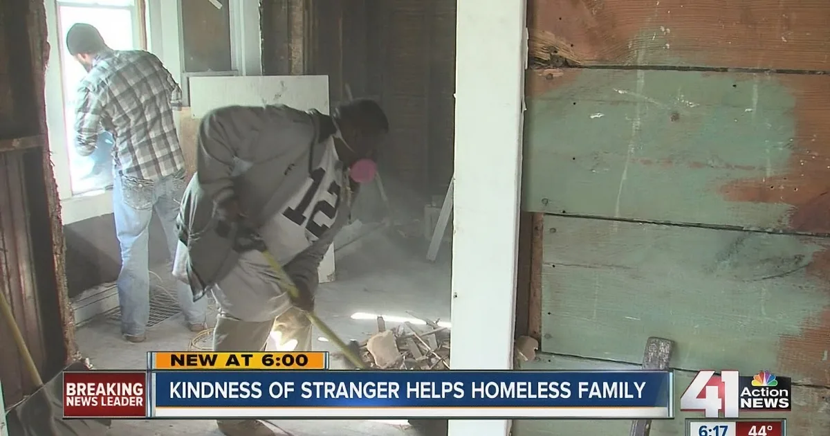 A man in a gray hoodie works on a home renovation, with another person in the background.