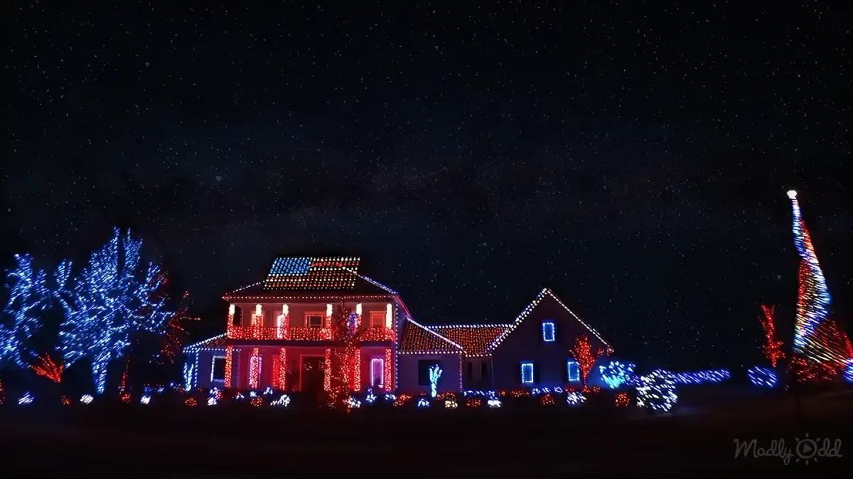 House with red, white, and blue Christmas lights. American flag on top.