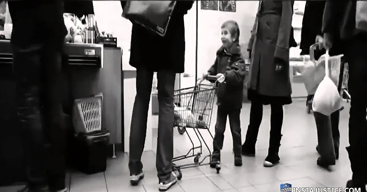 A child sits in a shopping cart amidst adults in a store, surrounded by bags and people.