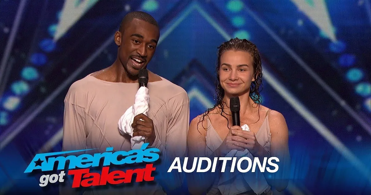 A man and woman, both shirtless, hold microphones on stage at America's Got Talent auditions.