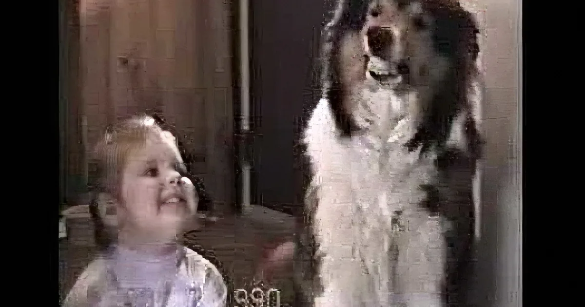 A baby and a dog are looking up, with the dog appearing to bark or howl.