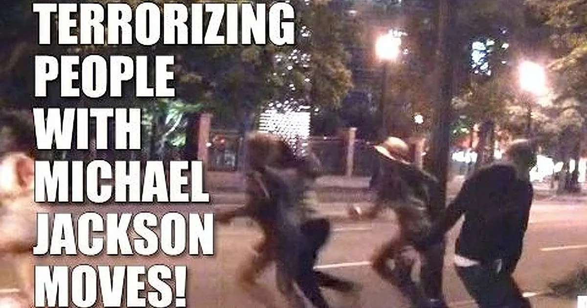 A person mimicking Michael Jackson's dance moves on a city street at night.
