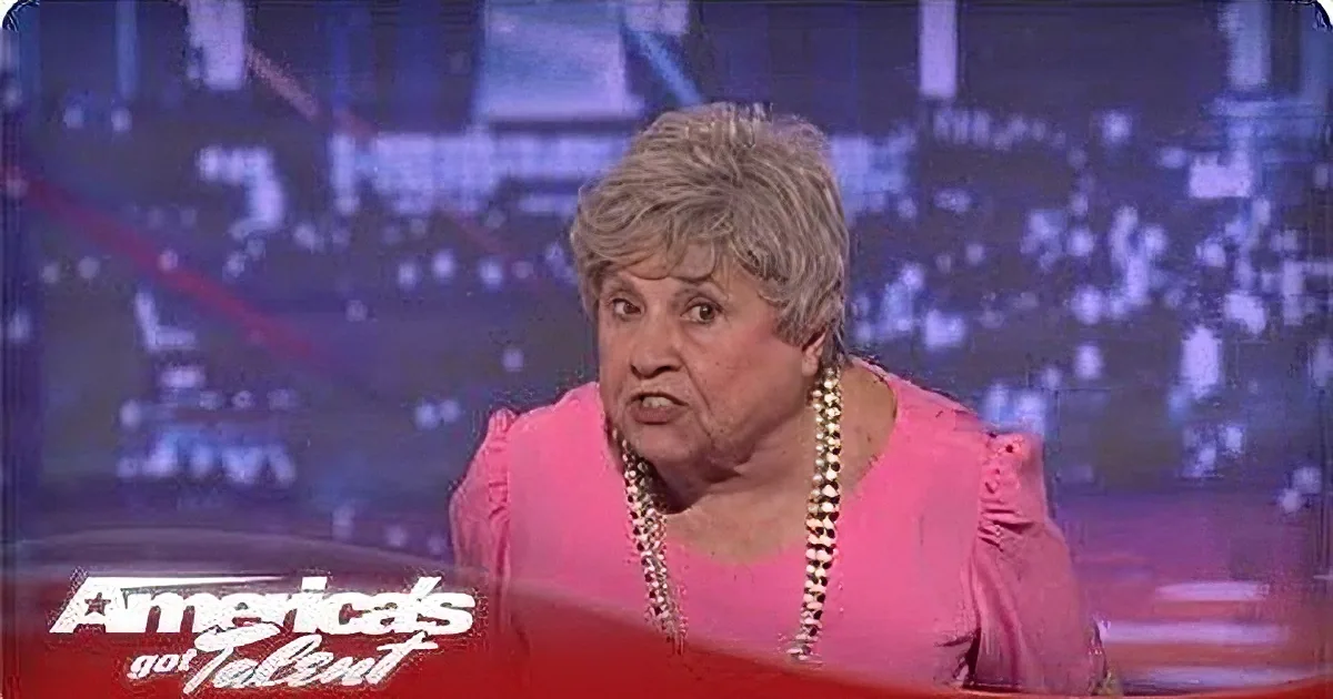A woman in a pink outfit is speaking on a stage with a "America's Got Talent" logo visible.