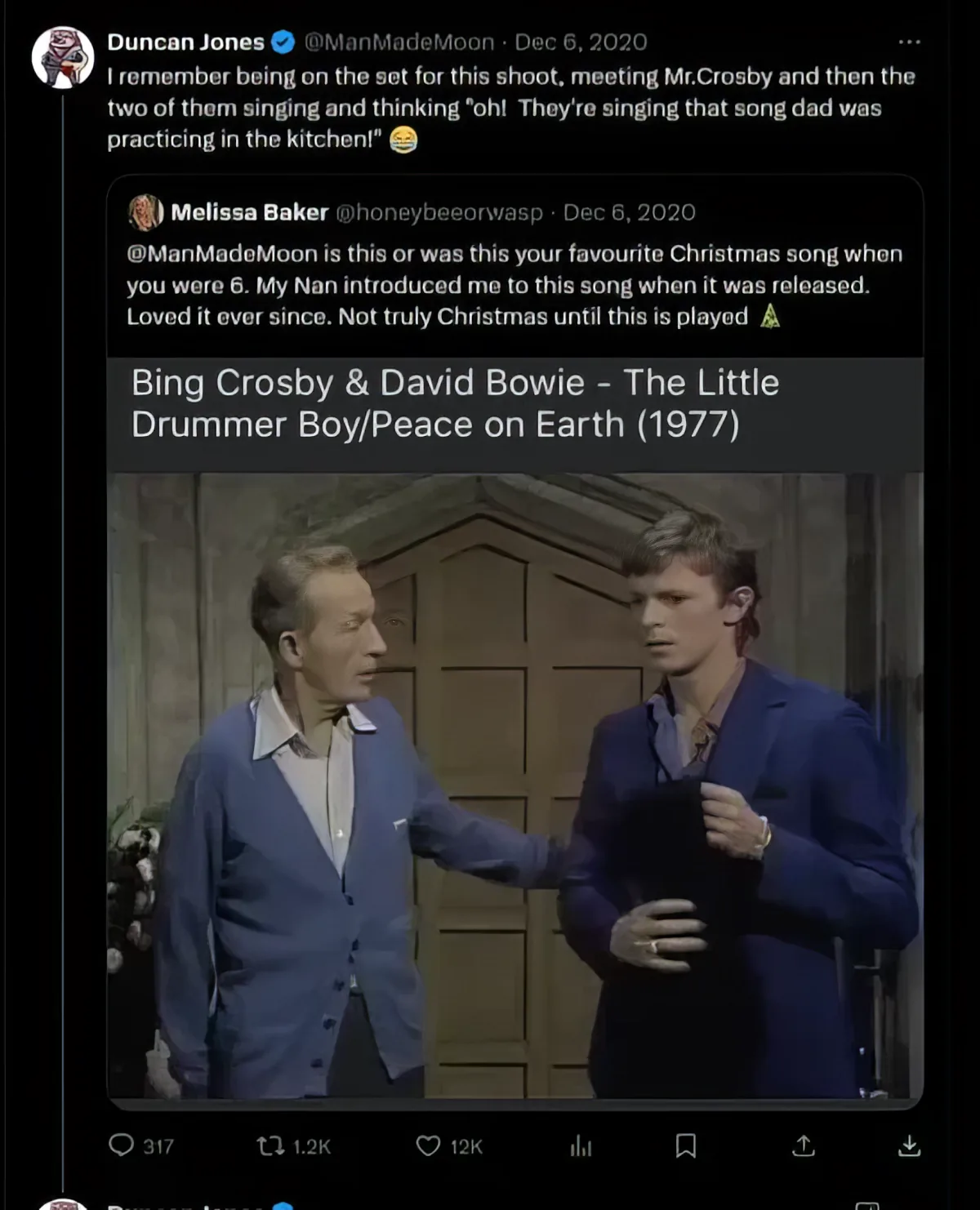 Screenshot of a tweet by Duncan Jones where he reminisces about being on set with Bing Crosby and his father, David Bowie, during the filming of their famous Christmas song duet. The tweet includes a response to a fan question and an image of Bing Crosby and David Bowie from the video.