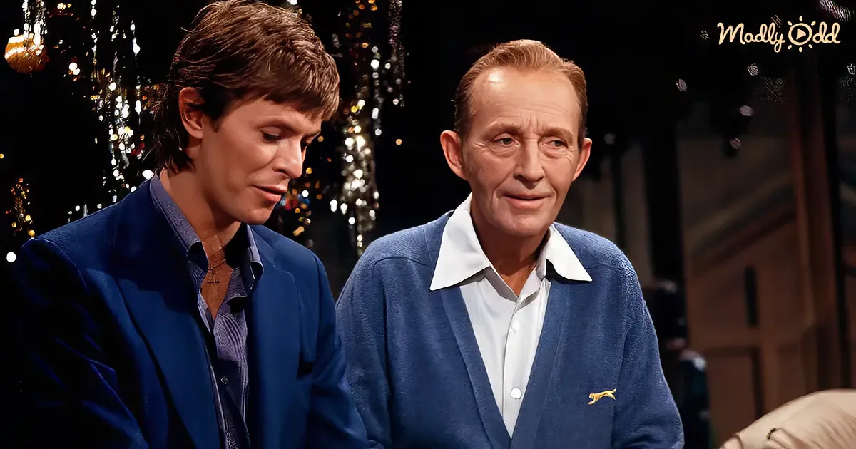 Two men in blue attire, one smiling, seated in a festive setting with sparkling decorations.