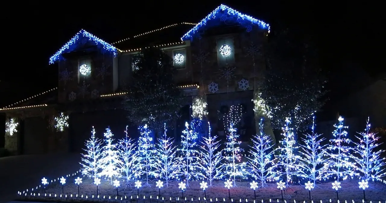 A house adorned with blue and white Christmas lights and snowflake decorations.