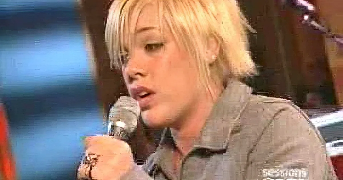 A person with blonde hair and a watch sings into a microphone, surrounded by smaller video clips.