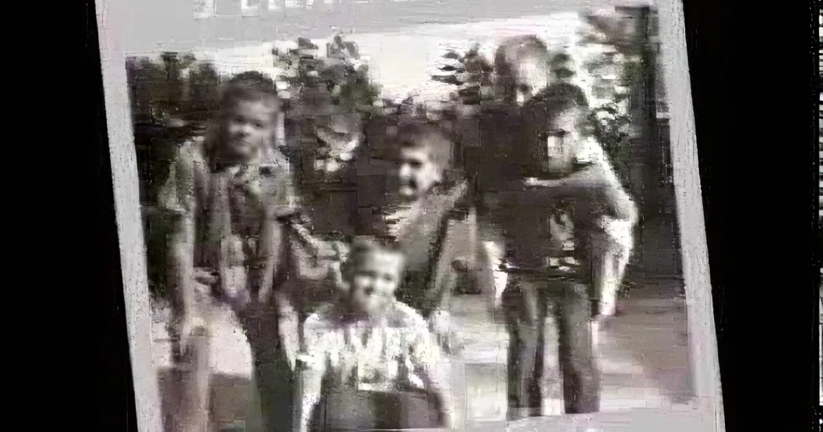 A group of children posing together in an old black-and-white photograph.