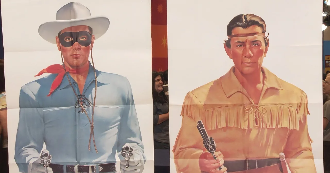 A cowboy and an Indian are depicted in traditional attire, each holding a gun, with a flag in the background.