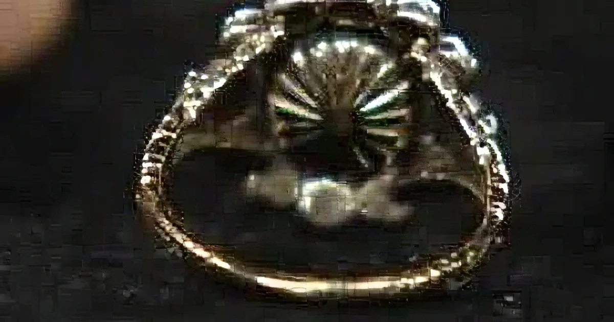 A close-up of an ornate, possibly antique, ring with intricate detailing and a central stone.