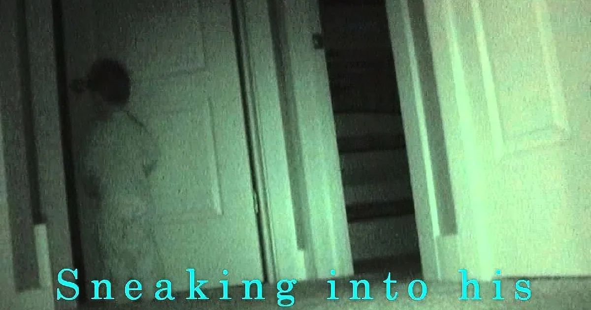 A shadowy figure sneaks into a dimly lit room, with stairs and a door visible in the background.