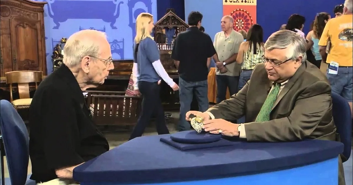 Two men in suits examine a watch at a table in a bustling folk art market.