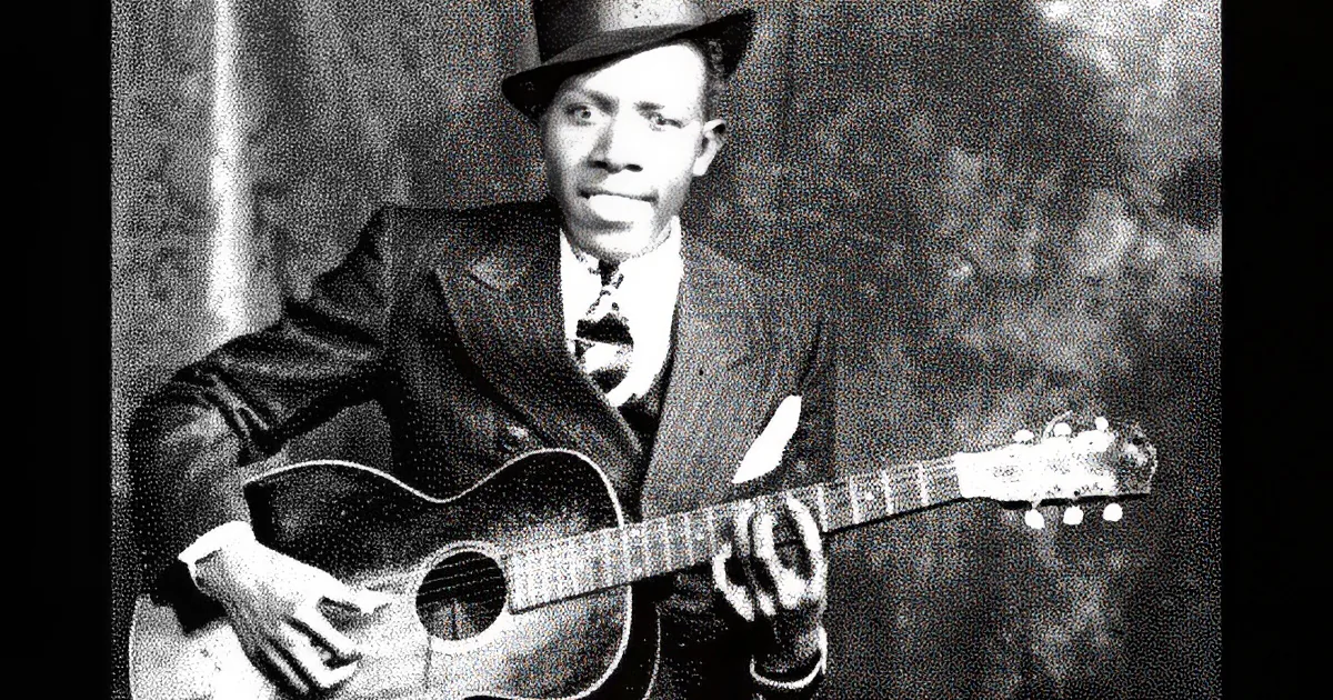 A man in a suit and hat plays a guitar, smiling, against a textured background.