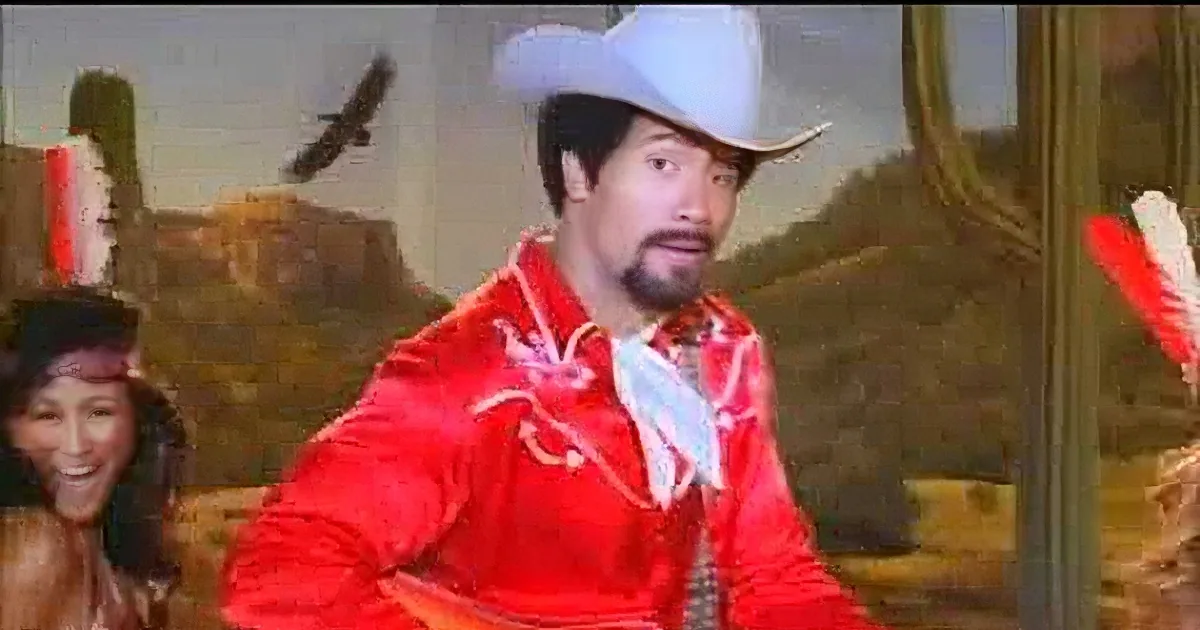 A man in a red cowboy outfit and white hat is dancing, surrounded by a desert landscape and a woman in the background.