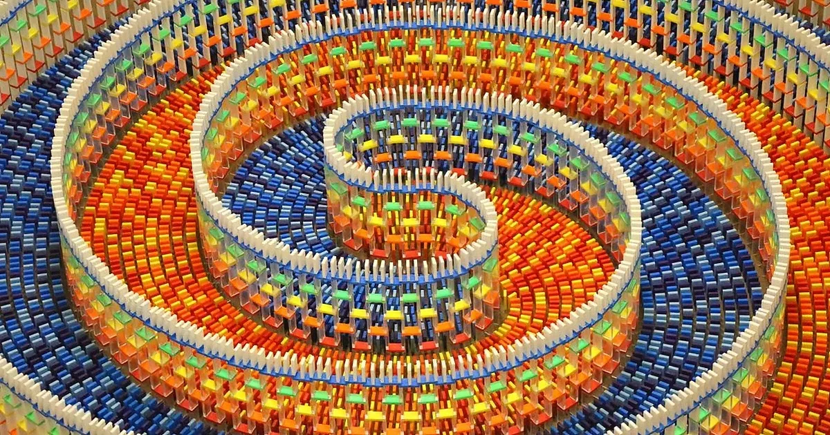 A colorful, intricate spiral structure made of small, interlocking pieces creates a mesmerizing pattern.
