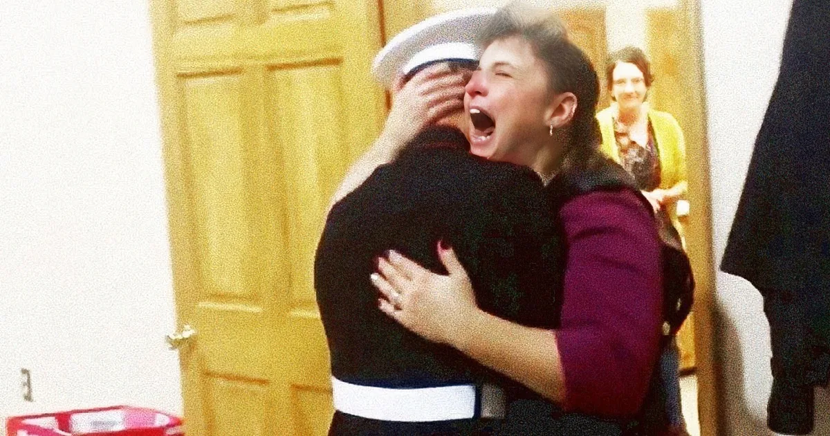 A woman in a sailor uniform hugs another woman tightly, both appearing emotional.