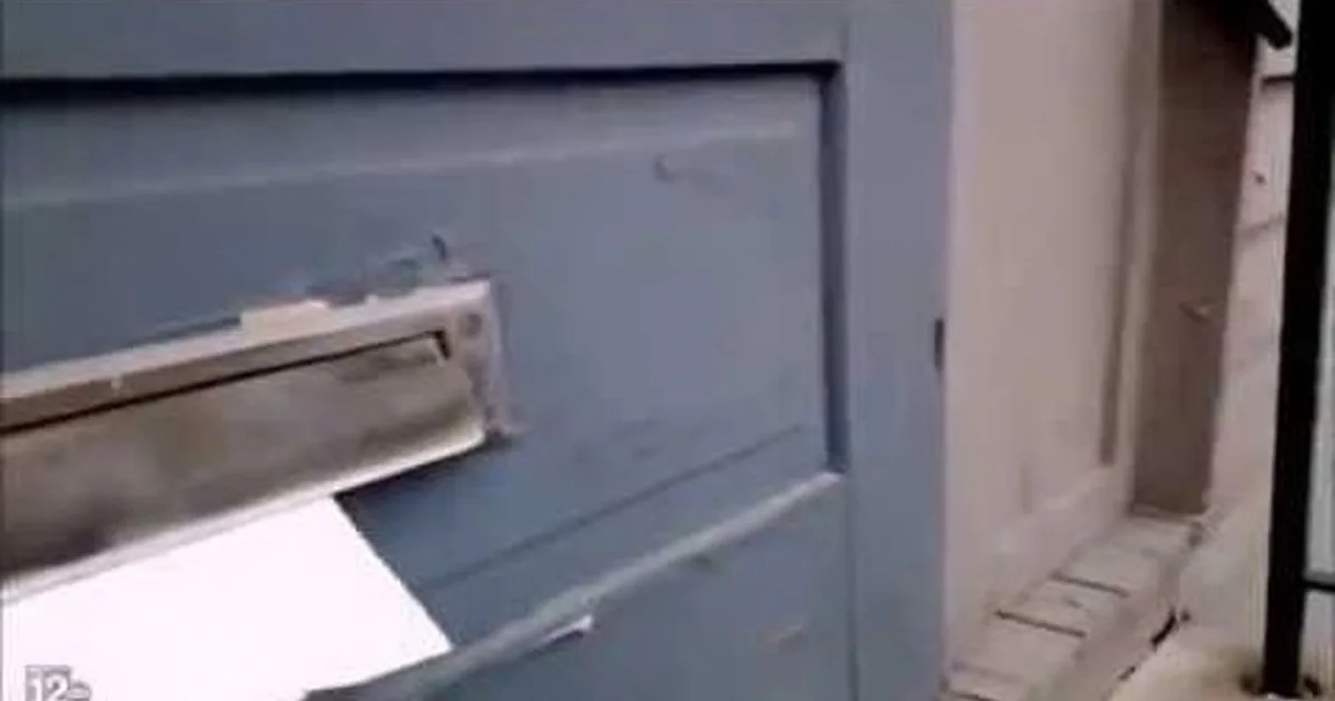 A close-up of a blue door with a metal mail slot and a small inset image of a hand holding a white envelope.
