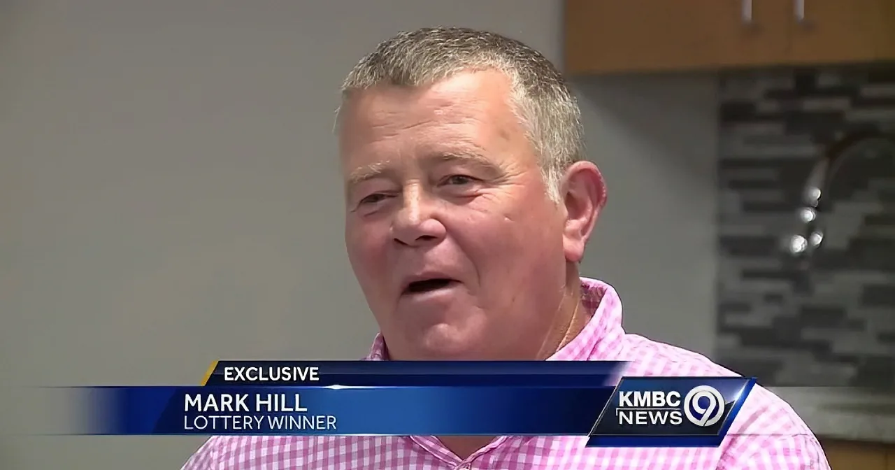 Mark Hill, a lottery winner, smiles in a pink checkered shirt, featured in KMBC News 9's exclusive segment.