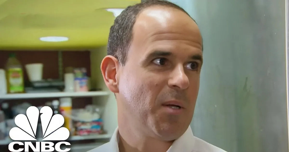 A man in a white shirt appears surprised or confused, with a kitchen background and the CNBC logo visible.
