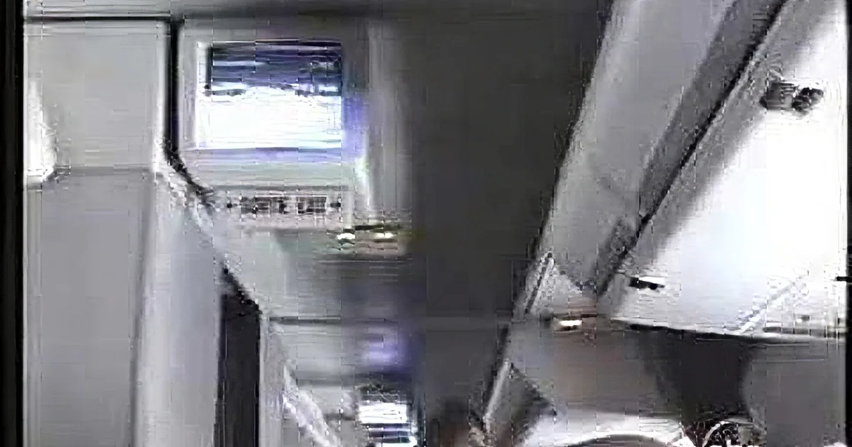 A close-up of an airplane's overhead panel with a screen and exit sign.