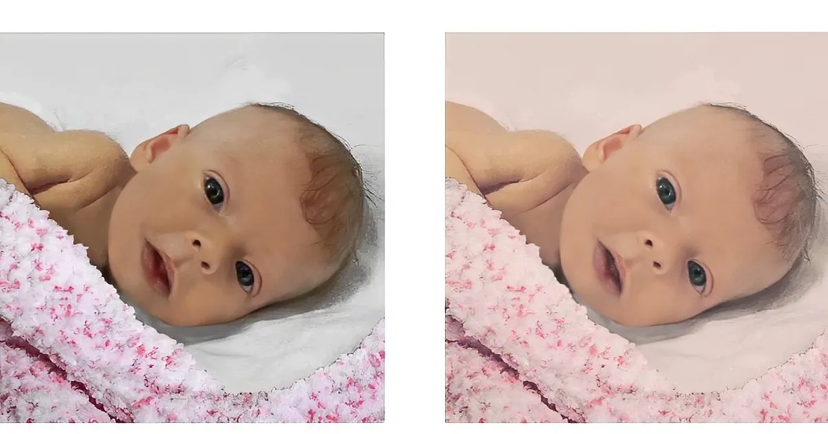 A newborn baby wrapped in a pink and white blanket, lying on a white surface.