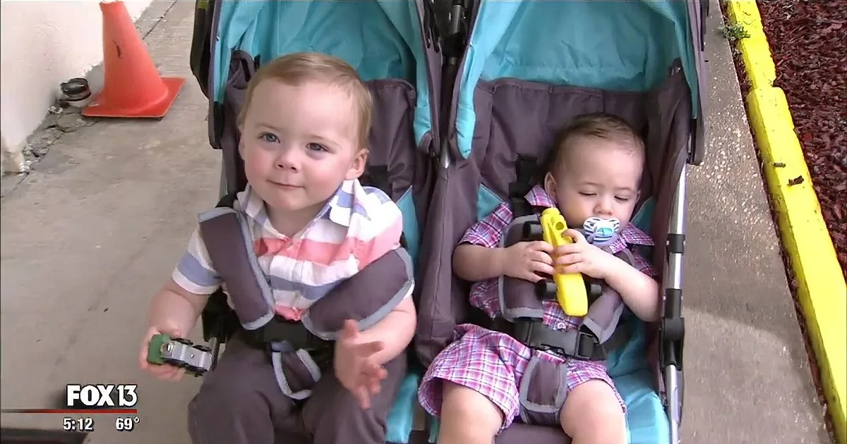 Two toddlers in a stroller, one holding a toy, both wearing plaid shirts, with a temperature of 69°F shown.