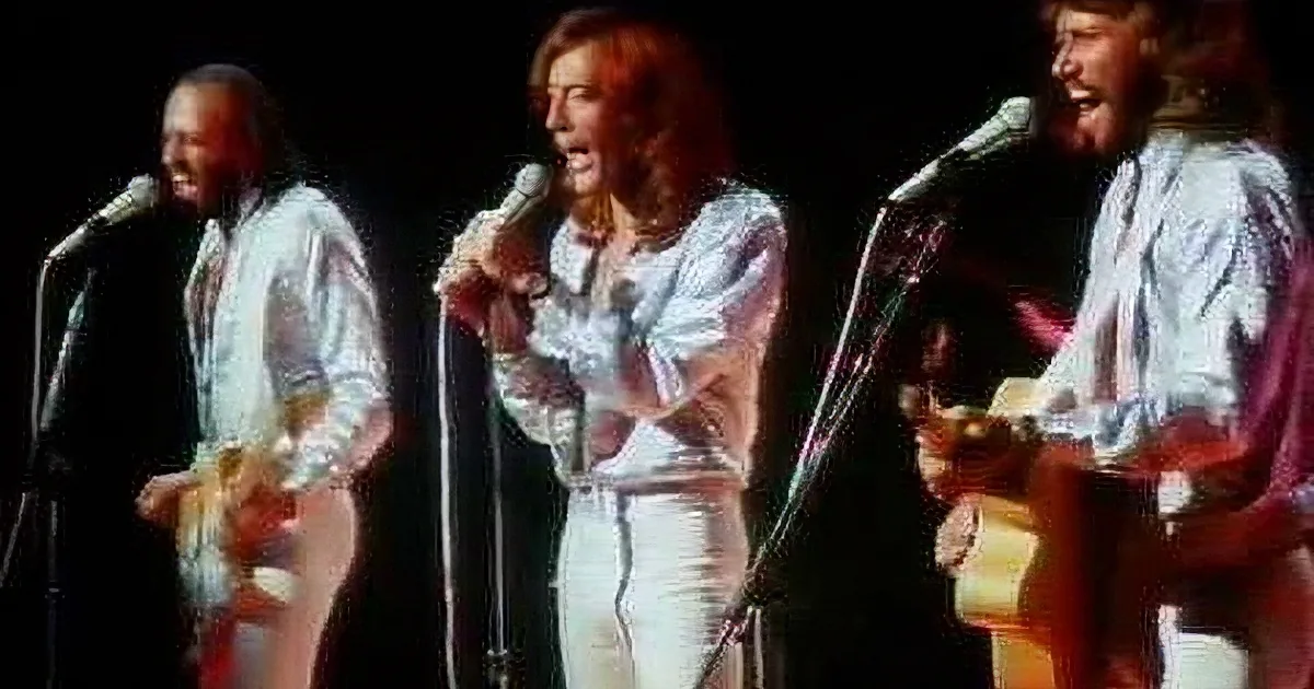 Three musicians in white shirts perform on stage, one playing guitar, another singing, and the third playing a stringed...
