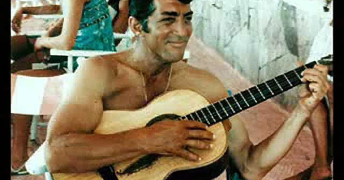 A shirtless man plays a guitar, smiling, with a collage of his hands and guitar in the background.
