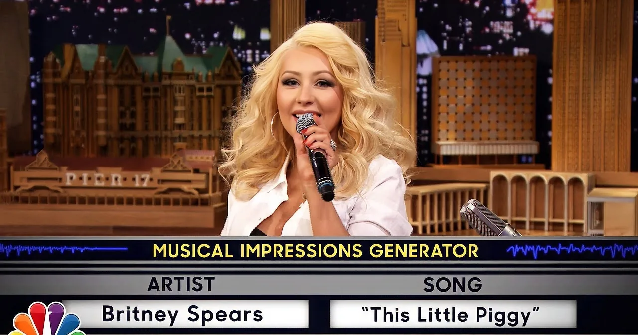 Britney Spears sings "This Little Piggy" on a TV show set with a cityscape backdrop.