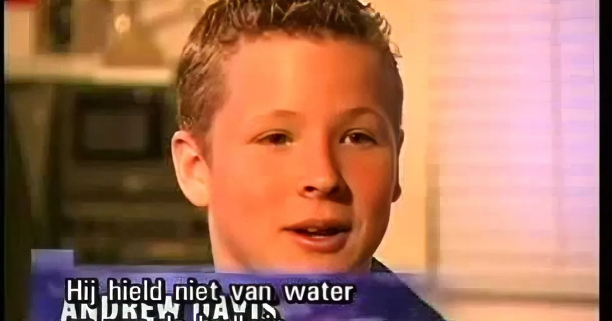 A young boy with short hair is speaking, subtitle reads "Hij hield niet van water."