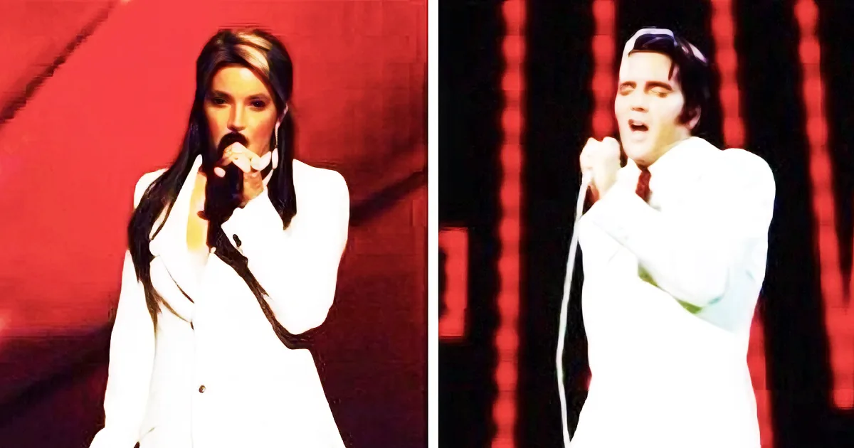 A person in a white suit sings into a microphone against a red backdrop.