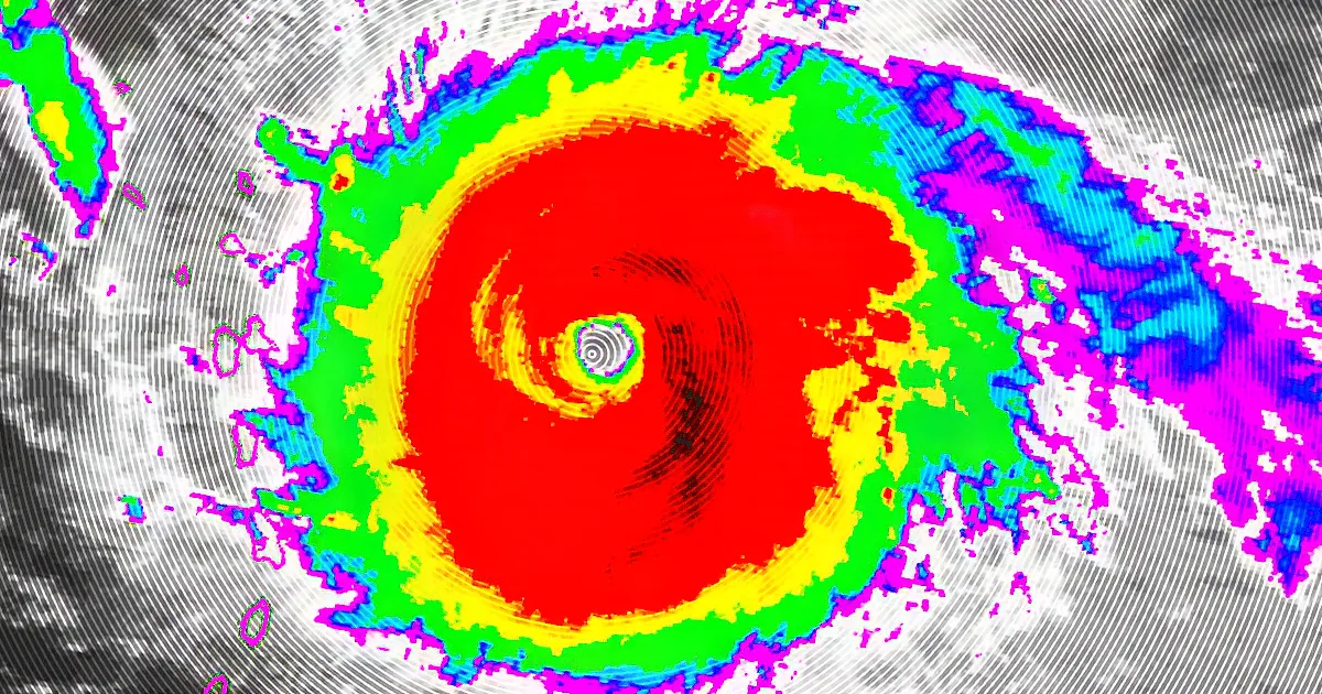 A satellite image shows a hurricane with a distinct eye and surrounding bands of varying colors.