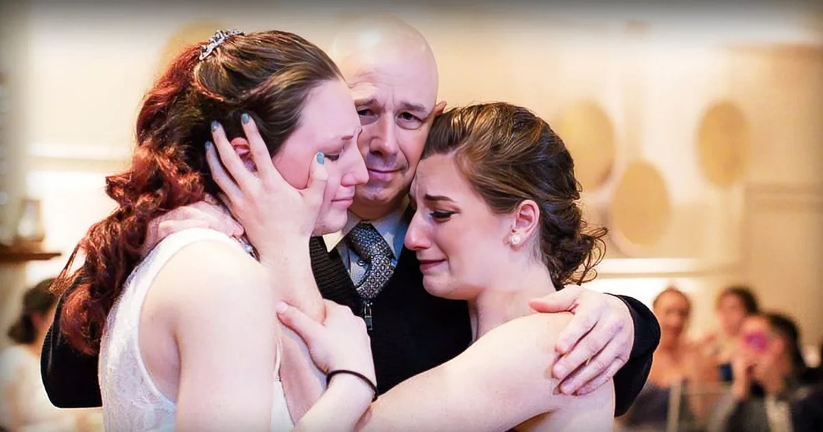 A bride, emotional, embraces her sister while a man, possibly her father, looks on with a mix of emotions.