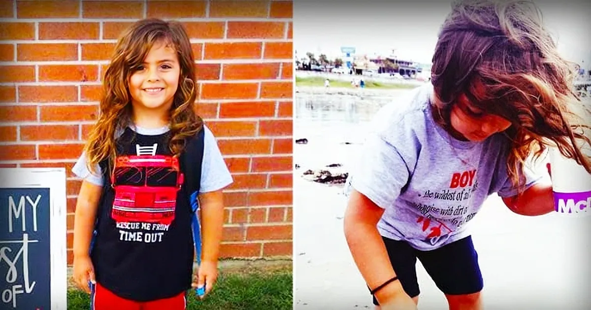A young girl with long hair, wearing a "Rescue Me From Time Out" shirt, smiles and bends down in front of a brick wall.