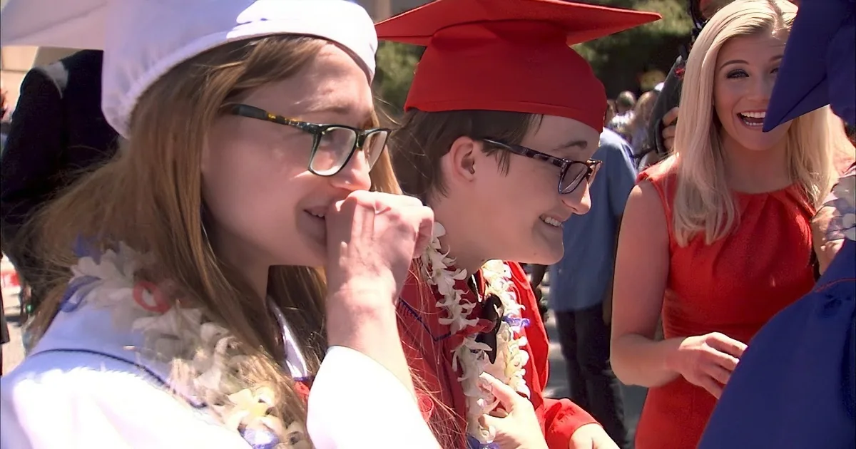 Graduates in caps and gowns share a moment of joy and celebration.
