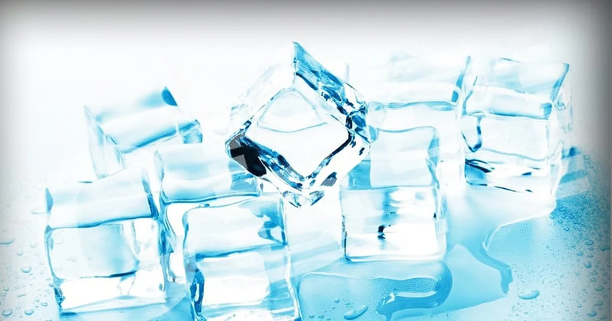Ice cubes with water droplets on a reflective surface, creating a cool blue tone.