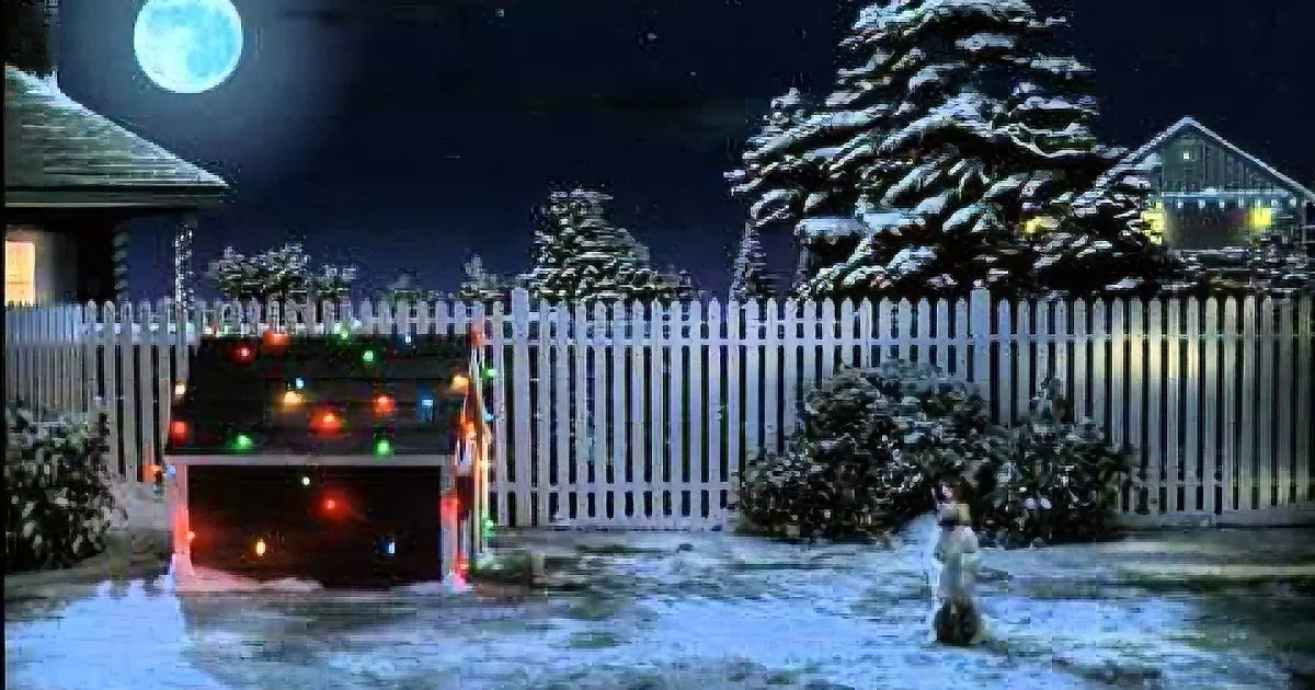 A snowy night scene with a decorated truck, white picket fence, and snow-covered trees.