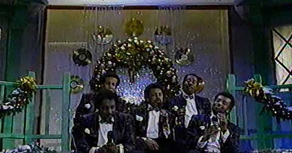 A group of men in formal attire, possibly singing or performing, with floral decorations and a festive backdrop.