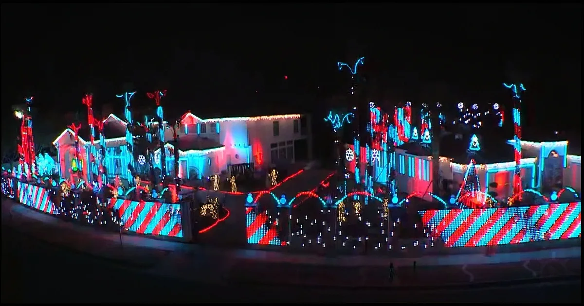 A house adorned with vibrant red, blue, and white Christmas lights and decorations.