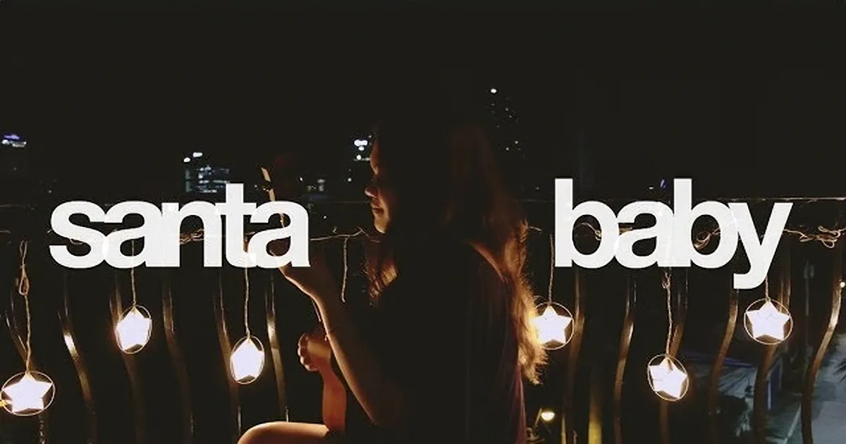 A person sits on a chair, holding a string of lights, with "santa baby" text on the left.