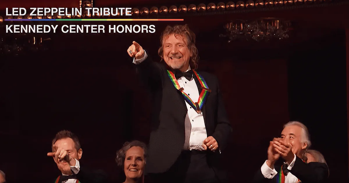 Robert Plant, wearing a medal, raises his fist in celebration at the Kennedy Center Honors.