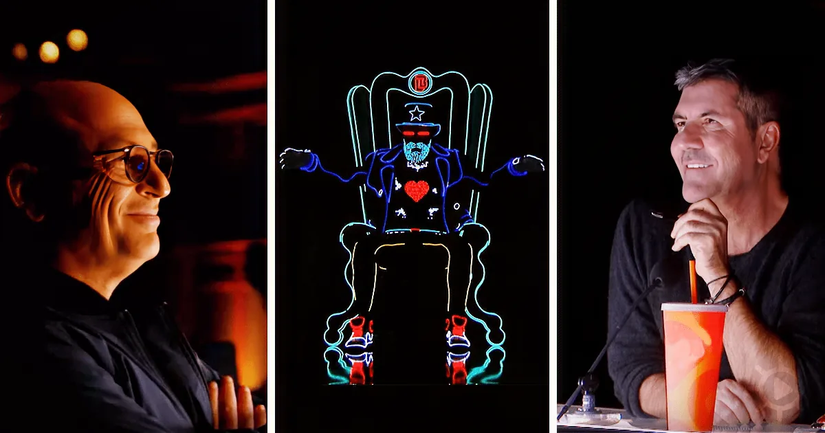 A man in a black shirt smiles, a neon figure in a chair with a heart, another man with a drink and microphone.
