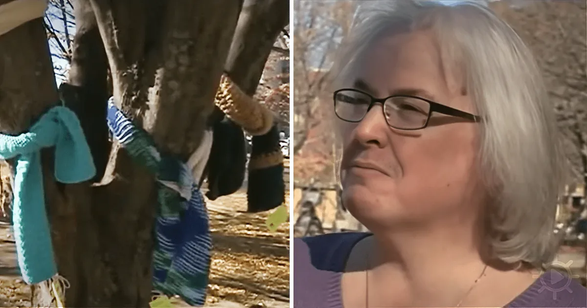 A woman with short gray hair and glasses looks to the side, wearing a purple top, with a tree adorned with colorful...