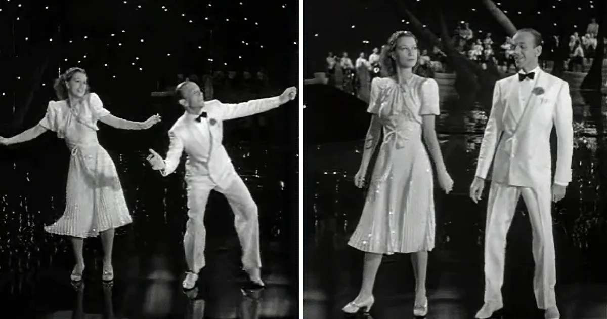 A man in a white tuxedo dances with a woman in a white dress on a stage with a starry backdrop.