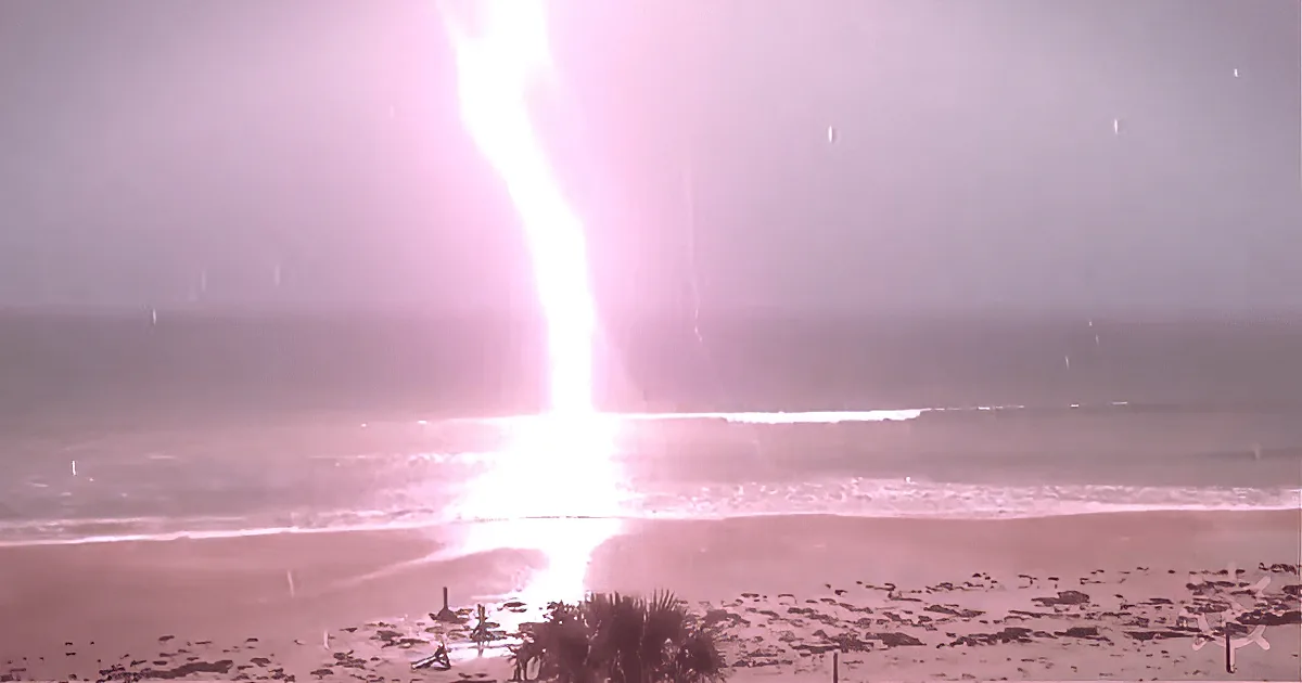 A bright, glowing beam of light pierces through a misty, beach-like environment.