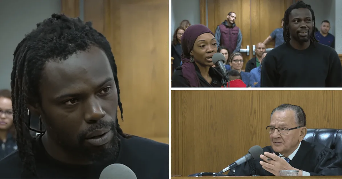 A man with dreadlocks speaks into a microphone in a courtroom setting.