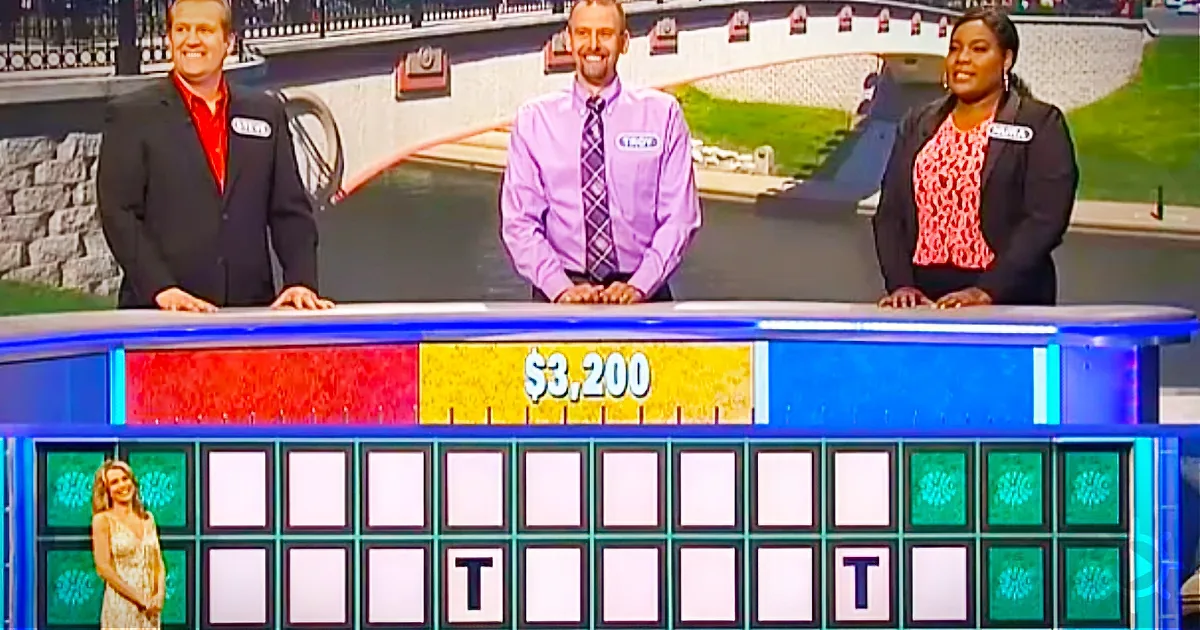 Three people stand behind a game show set with a $3,200 prize displayed.