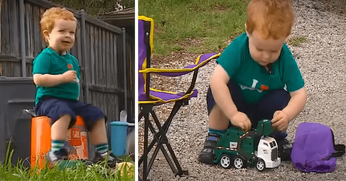 A toddler in a teal shirt plays with a toy truck on a gravel surface near a purple chair and trash can.