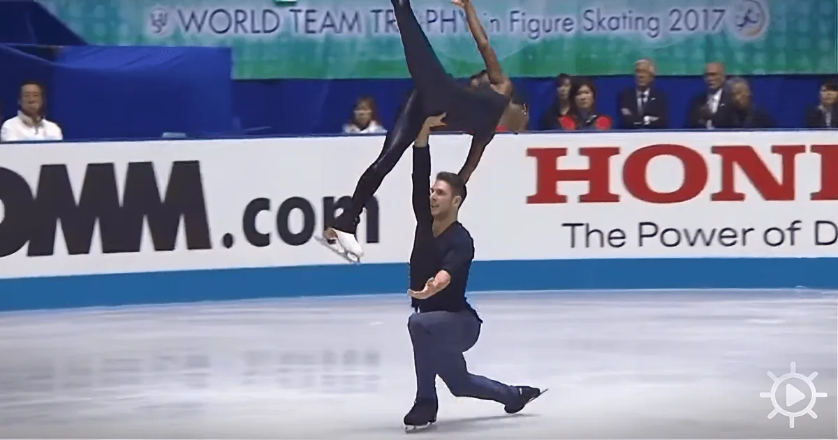 A figure skater lifts his partner in a dynamic pose on the ice.